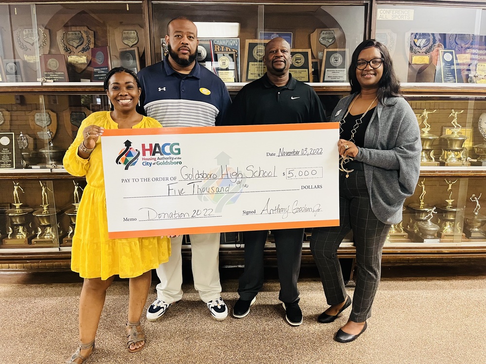 Goldsboro Housing Authority staff presenting Goldsboro High School principal and staff a donation.