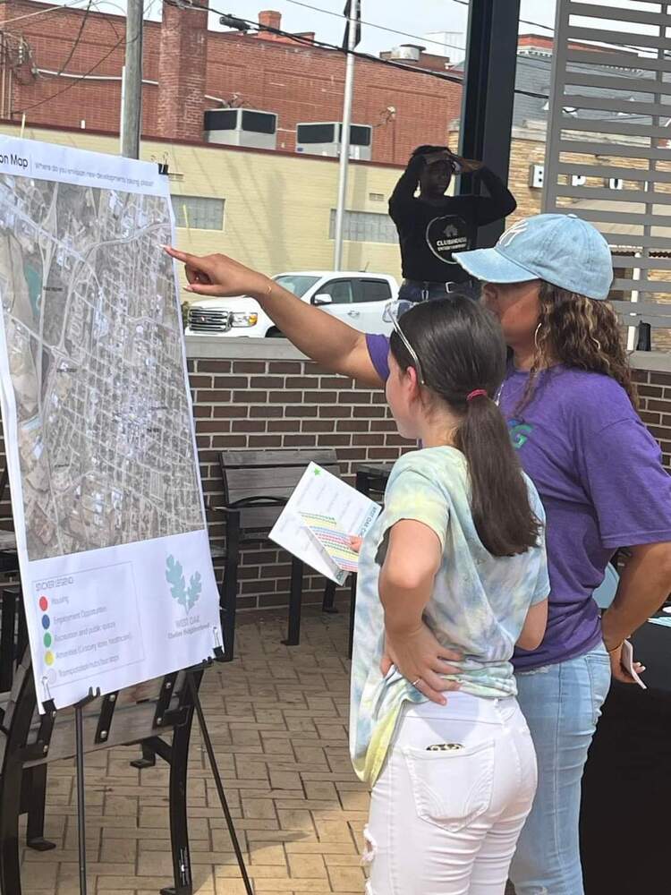 Staff showing event attendee a plan for West Oak