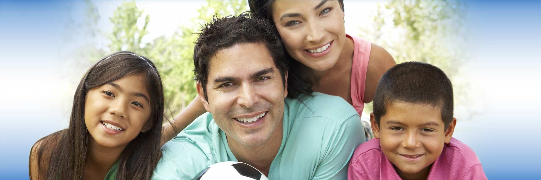 Family of four posing while playing soccer