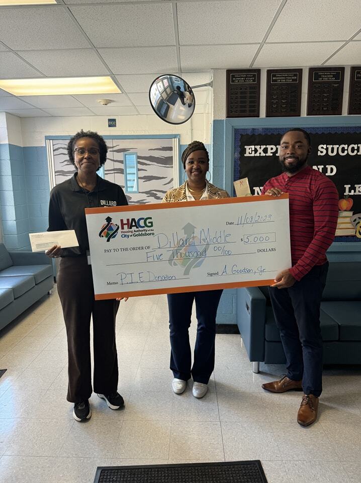 Dillard Middle School staff holding $5,000 donation from Goldsboro Housing Authority
