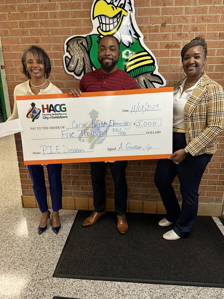 Carver Heights Elementary staff holding $5,000 donation from Goldsboro Housing Authority