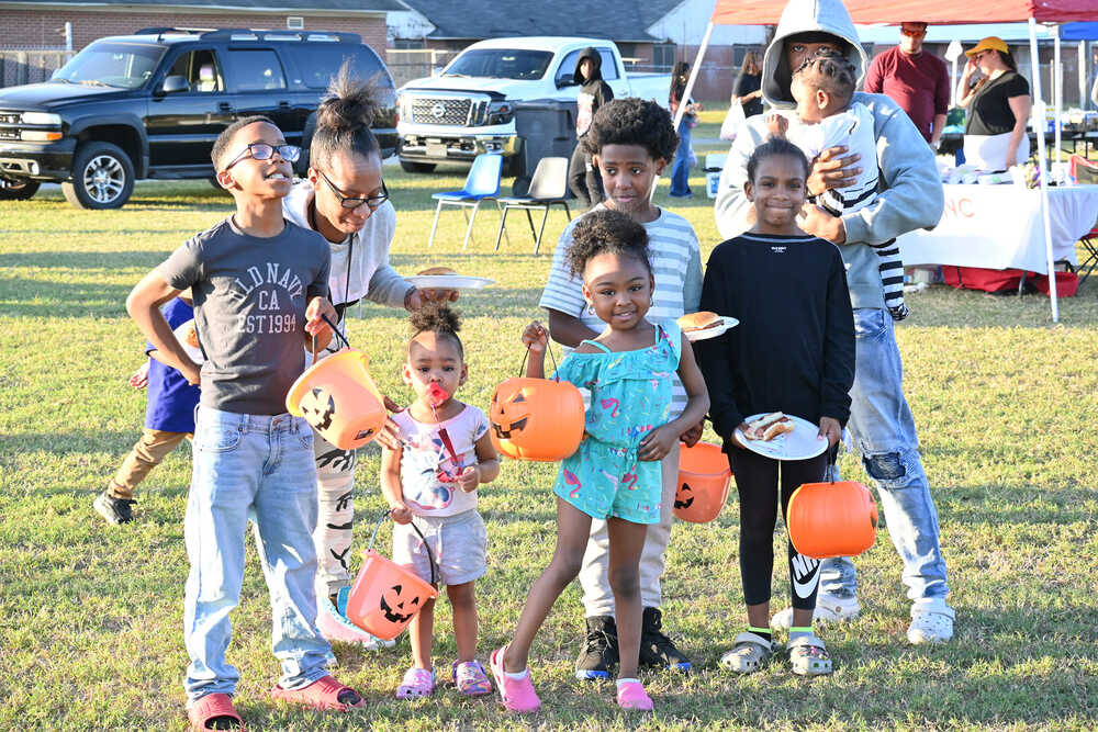 Youth posed with pumpkin treat totes outside at the fall festival event