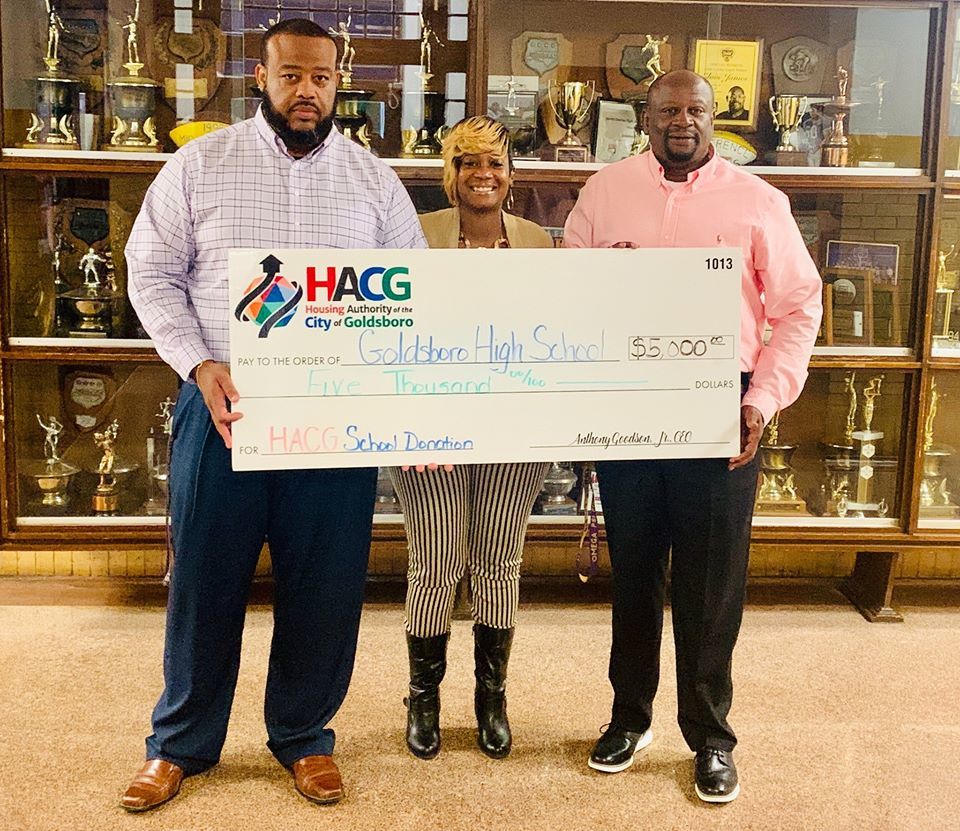 HACG staff with Goldsboro High School staff presenting check