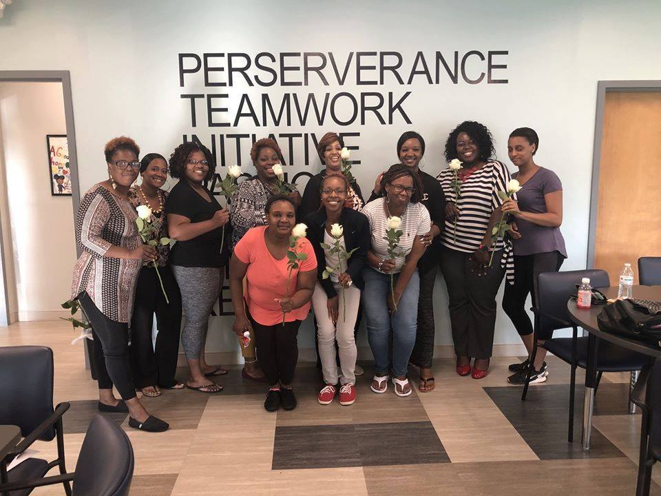 Pretty Tough Women's Support Group posing with stem roses at meeting