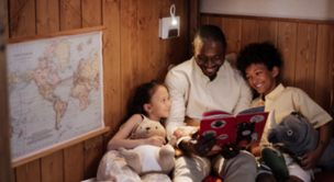 Dad reading a book to two children