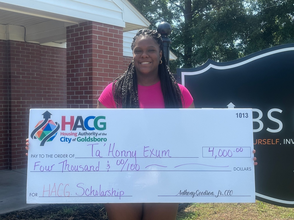 Ta'Honny Exum holding HACG Scholarship check for $4000